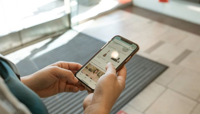 The image shows a person using an iPhone.— Pexels