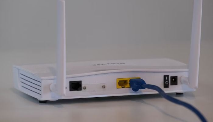 Broadband internet router with ethernet cable plugged into the back in the ethernet port. — Unsplash