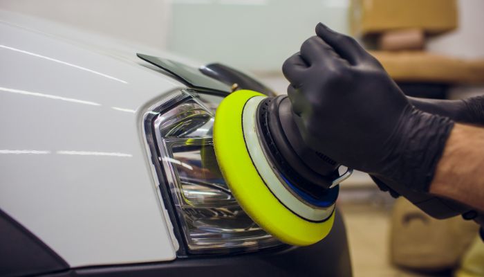 An undated image illustrating a person using the headlight restoration kit. — Canva