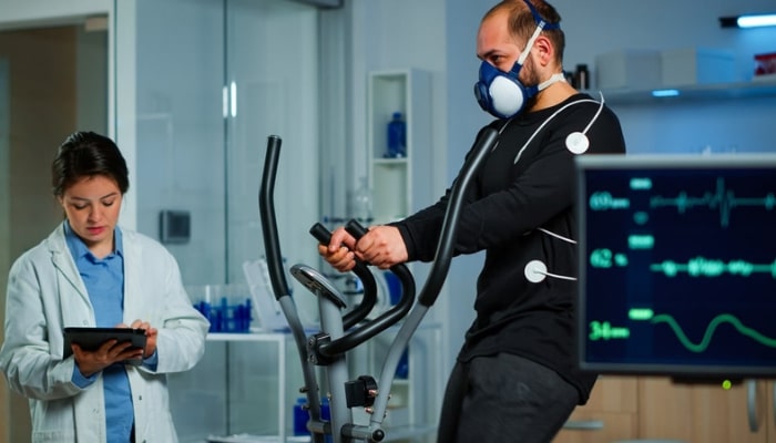 A representational image of a doctor measuring VO2 of a guy. — Canva