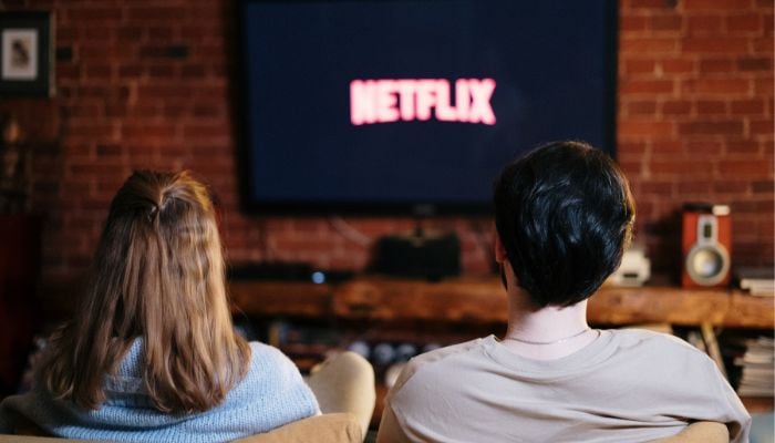An undated image illustrating a couple watching Netflix. — Canva