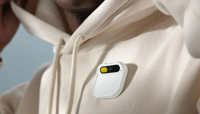 The image shows a person wearing an AI pin by Humane on their shirt.— Humane