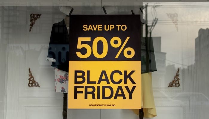 The image shows a poster saying Save up to 50% Black Friday. — Unsplash
