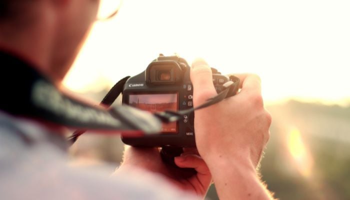 An undated image illustrating a person using DSLR. — Canva