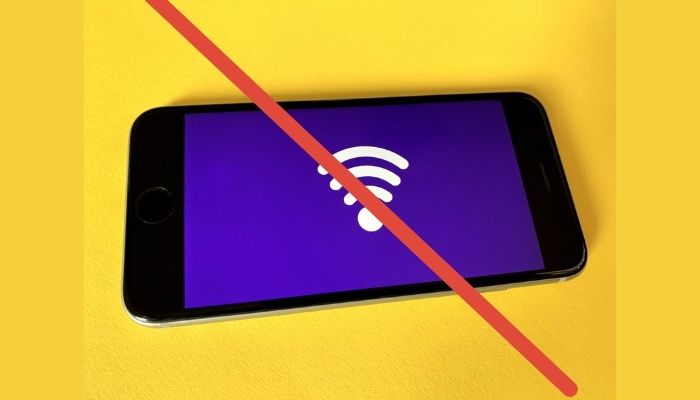 The image shows a wifi symbol on a phone screen and a red line cutting through. — Unsplash
