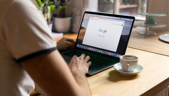 A person using a laptop at a coffee shop. — Unsplash