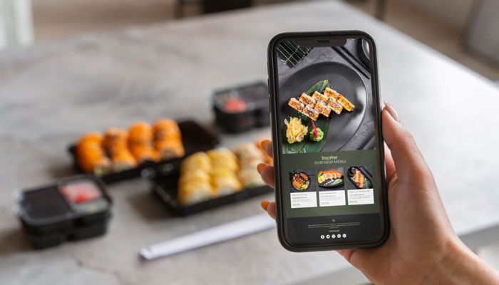 A representational image of a person using a cooking app on a mobile phone. — Freepik