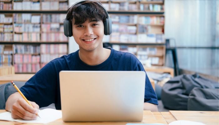 An undated image illustrating a student using a laptop. — Canva