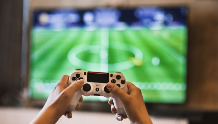 An undated image illustrating a person playing a video game. — Canva