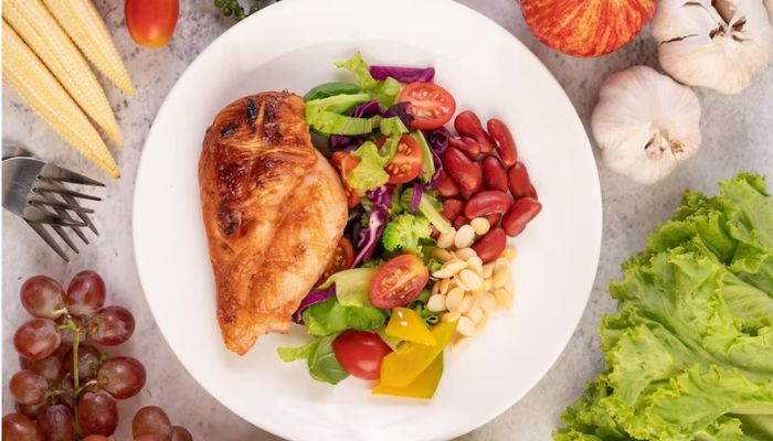 The image shows chicken breast with fruits and vegetables. — Freepik