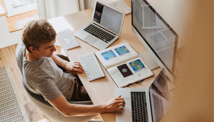 An undated image illustrating a person with programming gadgets. — Canva