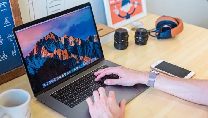 The image shows a person using a MacBook Air. — Unsplash