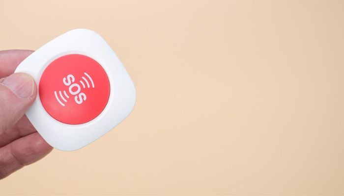 The image shows a hand holding an SOS badge. — Freepik