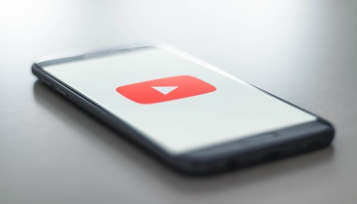An undated image displaying YouTube logo on a mobile screen. — Unsplash