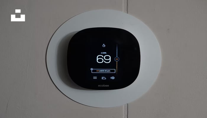 An undated image showing a smart thermostat installed on a wall. — Unsplash