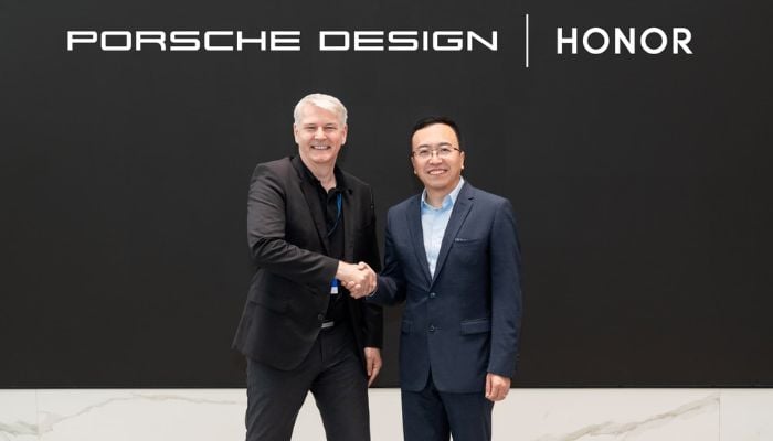Honor CEO George Zhao shakes hands with Porsche Lifestyle Group CEO Stefan Büscher after signing the deal on December 14, 2023. — Honor