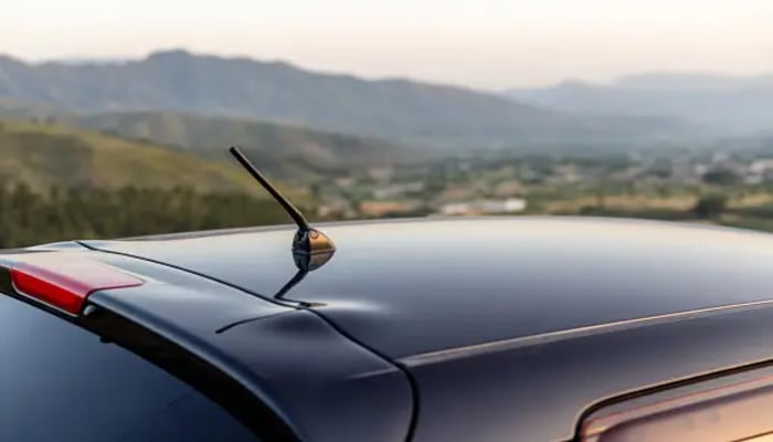 The image displays an antenna placed on a cars rooftop. — Unsplash