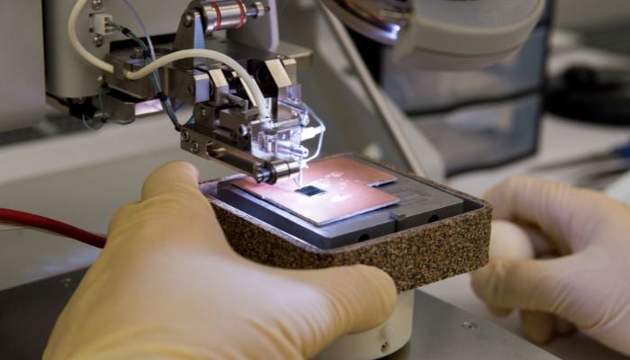 An undated image illustrating a person working semiconductor chip. — Canva