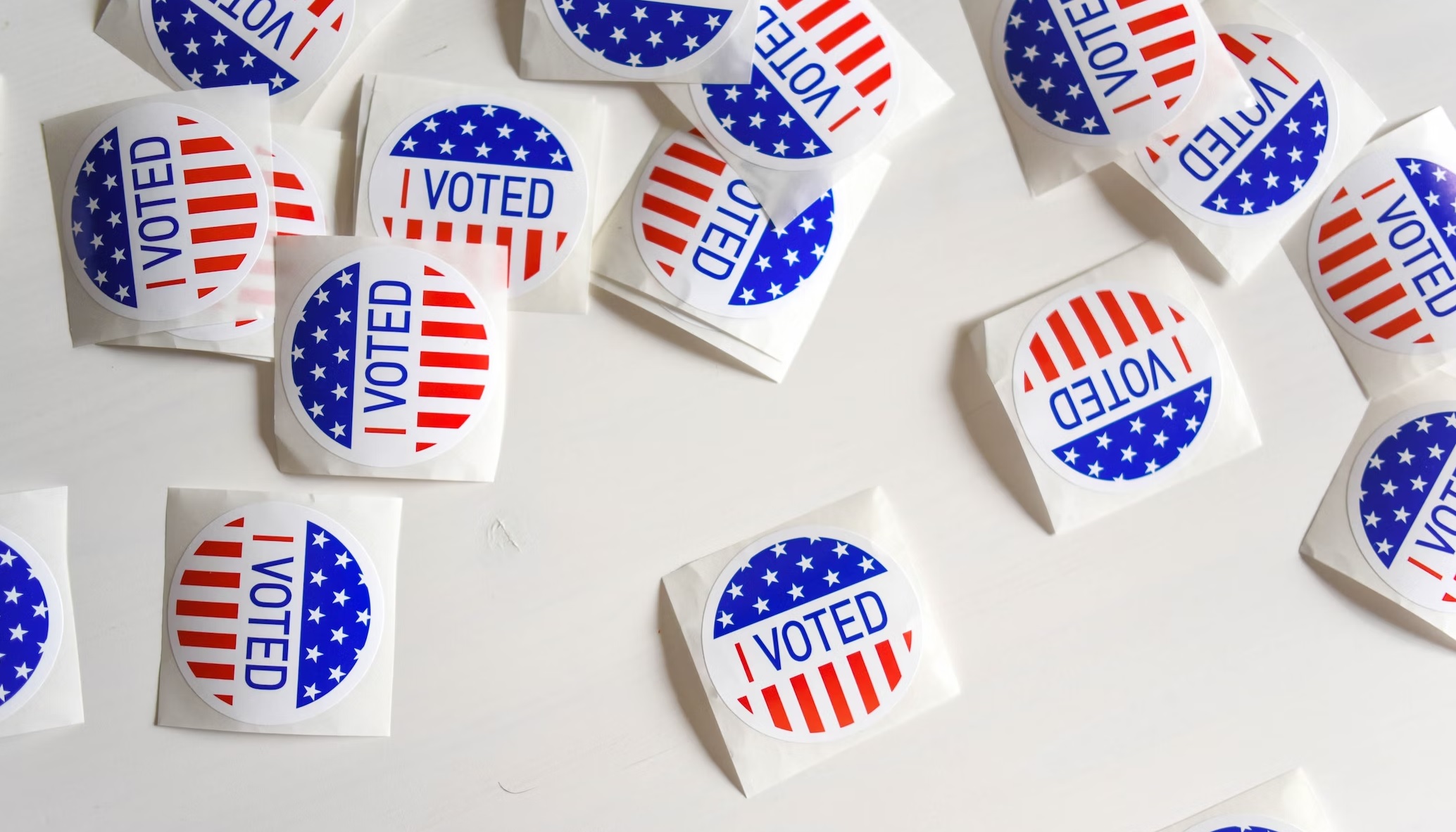 The image shows US election vote badges. Unsplash
