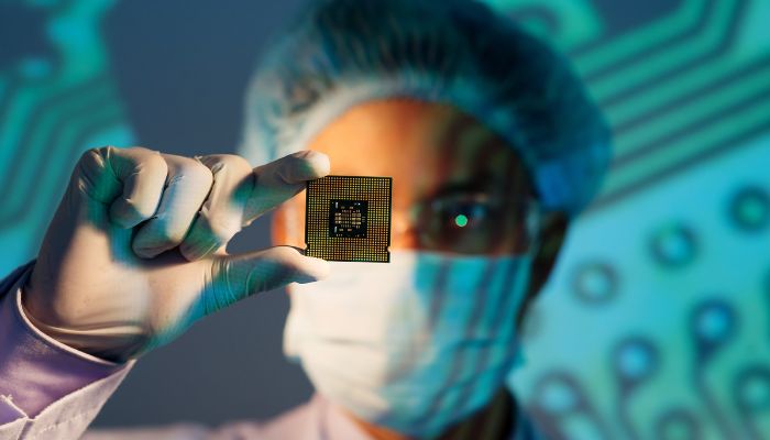 An undated image illustrating a person holding a semiconductor. — Canva