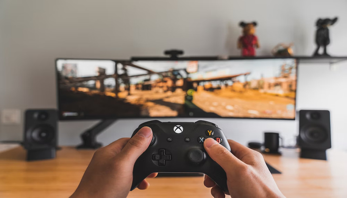 The image shows a person playing games on Xbox. — Unsplash
