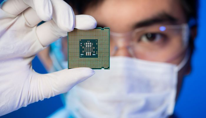 An undated image illustrating a person holding a microchip. — Canva