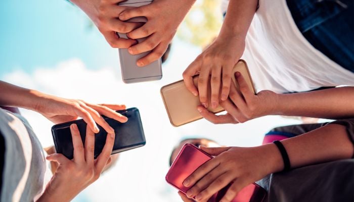 An undated image illustrating kids using smart phones. — Canva