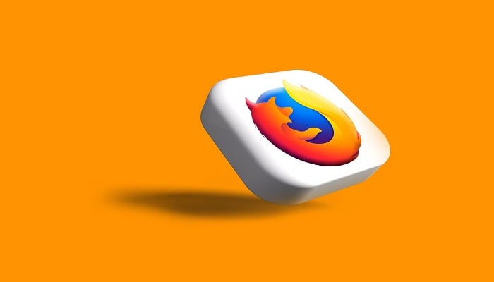 The image shows the Firefox logo on an orange background. — Unsplash