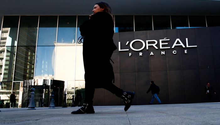A woman walks by the logo of French cosmetics group LOreal in the western Paris suburb of Levallois-Perret, France, February 7, 2020. — Reuters