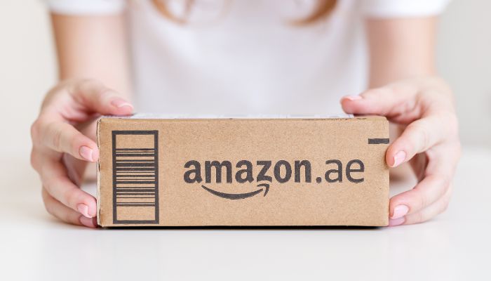 An undated image of a woman holding an Amazon box. — Canva