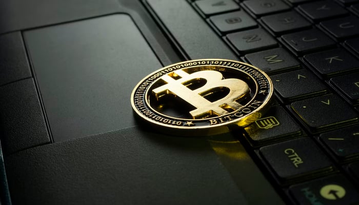 A representational image of a Bitcoin placed on a laptop. — Unsplash