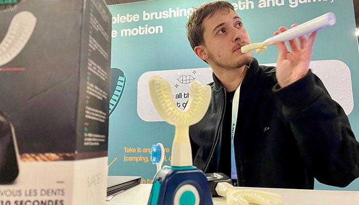 Jad Sassine from Hydro-One, demonstrate how to use the Y-Brush, an electric toothbrush supposed to clean the teeth in only 20 seconds total, during the Consumer Electronics Show (CES) in Las Vegas, Nevada, on January 11, 2024. — AFP