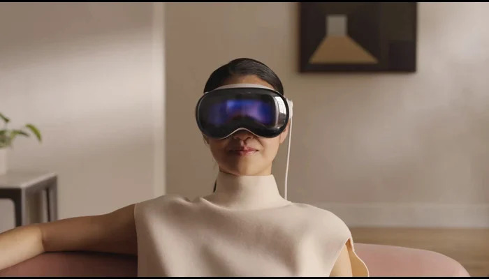 The image shows a woman wearing an Apple Vision Pro. — Apple