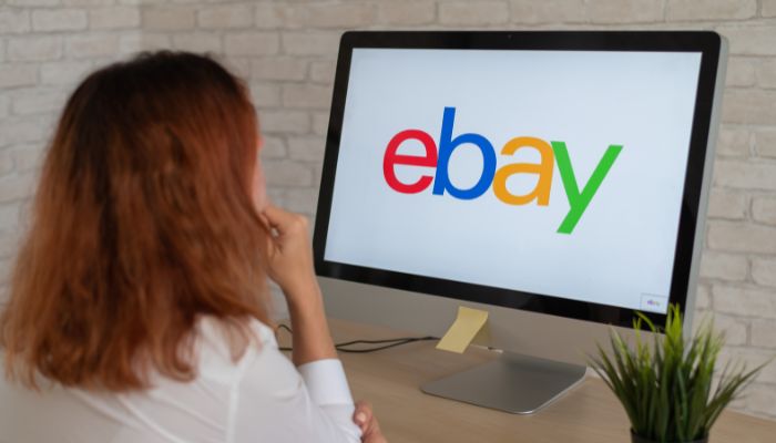 An undated image of a girl looking at the home page of the eBay website. — Canva