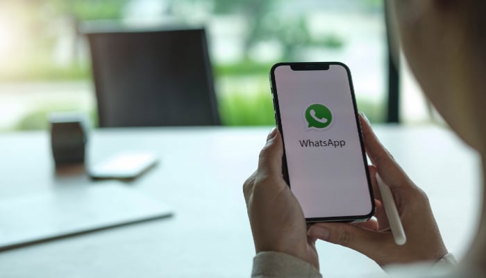 An undated image of the Whatsapp icon is displayed on a mobile screen. — Canva