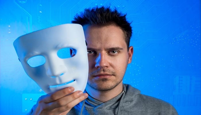 The image shows a man holding a mask. — Freepik