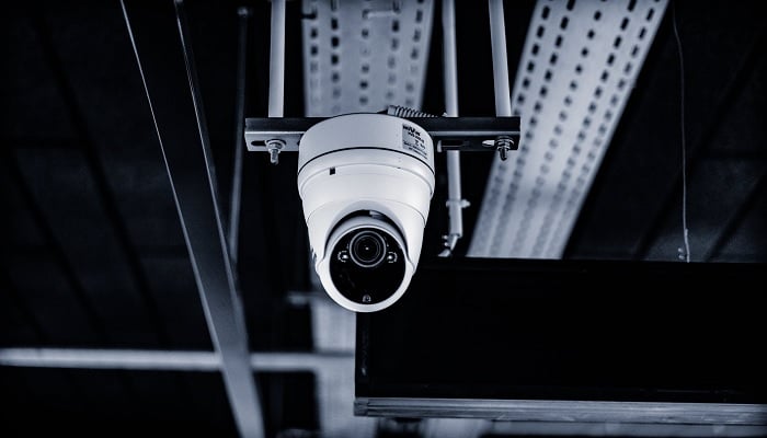 The image shows a white CCTV camera.
