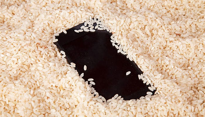 An undated image of a phone placed on a bag of rice. — iStock