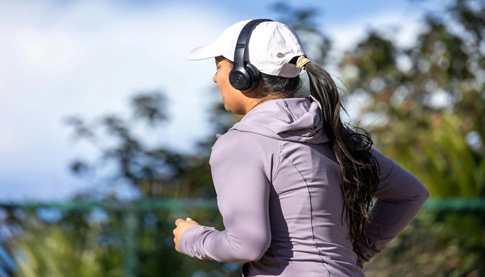 The image shows a person running with headphones on. — Pexels
