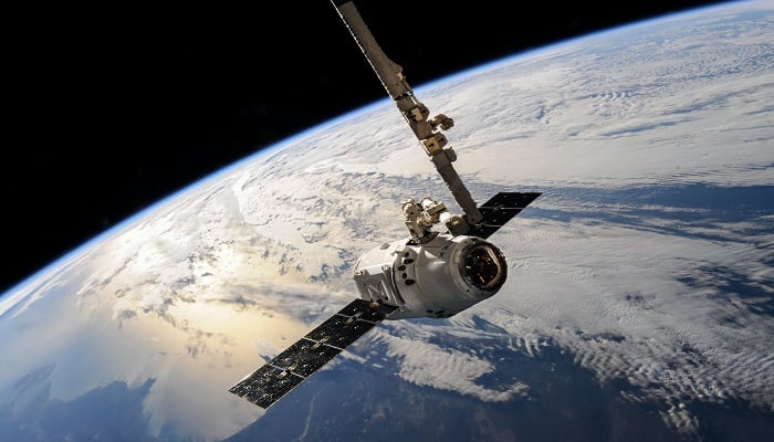 The image shows a satellite orbiting the Earth. — Pexels