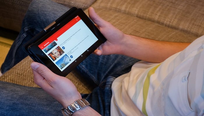 The image shows a person using YouTube. — Pexels