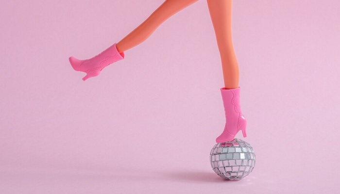 The image shows barbie legs on a disco ball. — Freepik