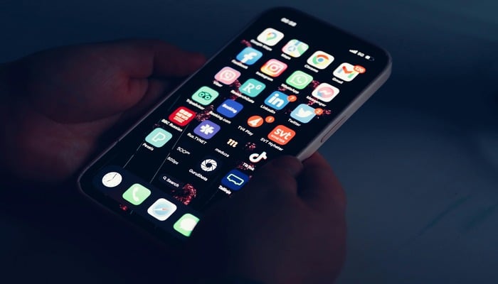 An undated image showing a man holding iPhone. — Pexels