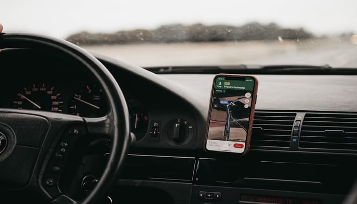 An undated image displaying Google Maps on a mobile phone in a car. — Unsplash