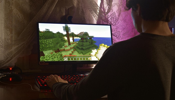 The image shows a person playing a game on PC. — Pexels