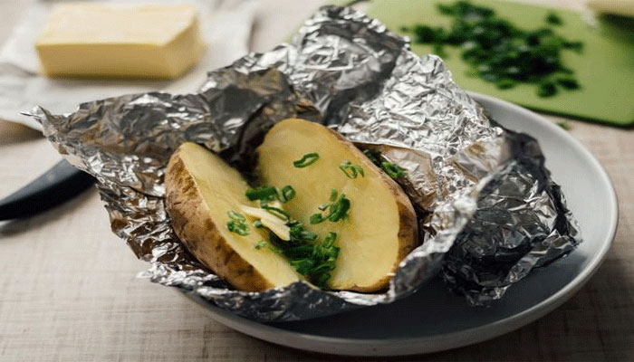 Half-done food placed in aluminium foil to cook. — Canva
