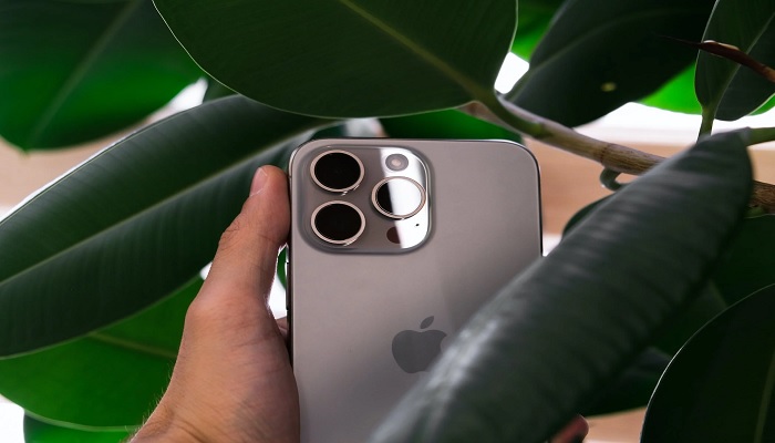 The image shows a person holding iPhone 15, possibly the predecessor to iPhone 16 series. — Pexels