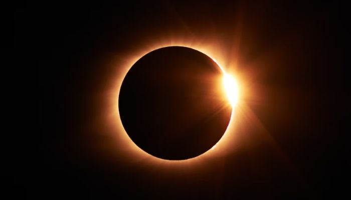 The image is an undated stock photo of a total solar eclipse. — Unsplash