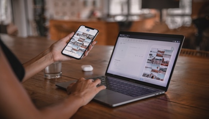 An undated image of a person using a phone and laptop. — Unsplash