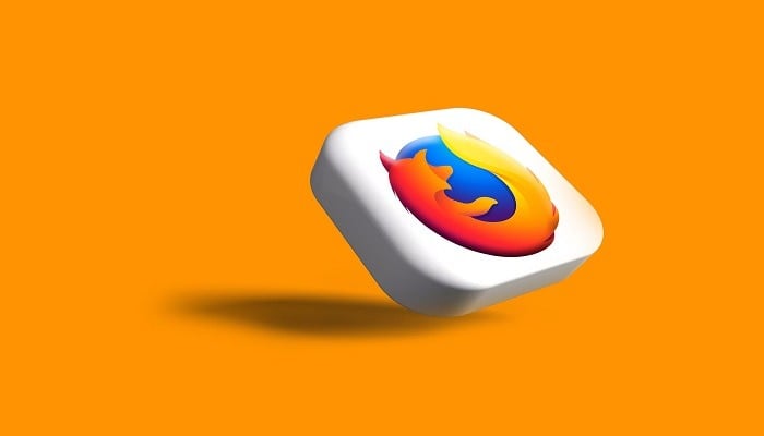 The image shows the Firefox logo on an orange background. — Unsplash